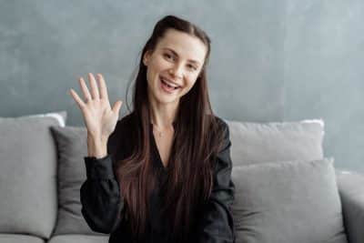 woman speaking and waving to the camera
