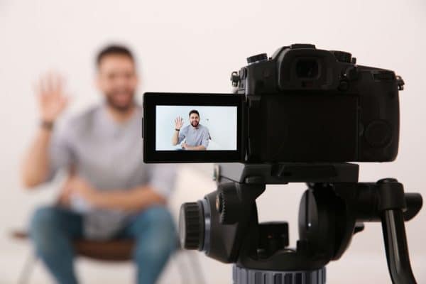 man sitting in front of a camera to record a video