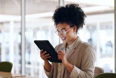 woman using tablet and smiling