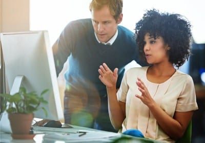 man working with woman at computer