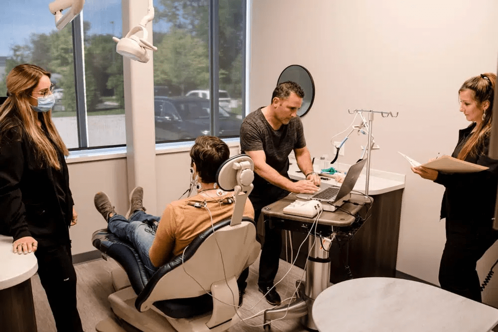Dental team performing diagnostic testing on patient in exam chair