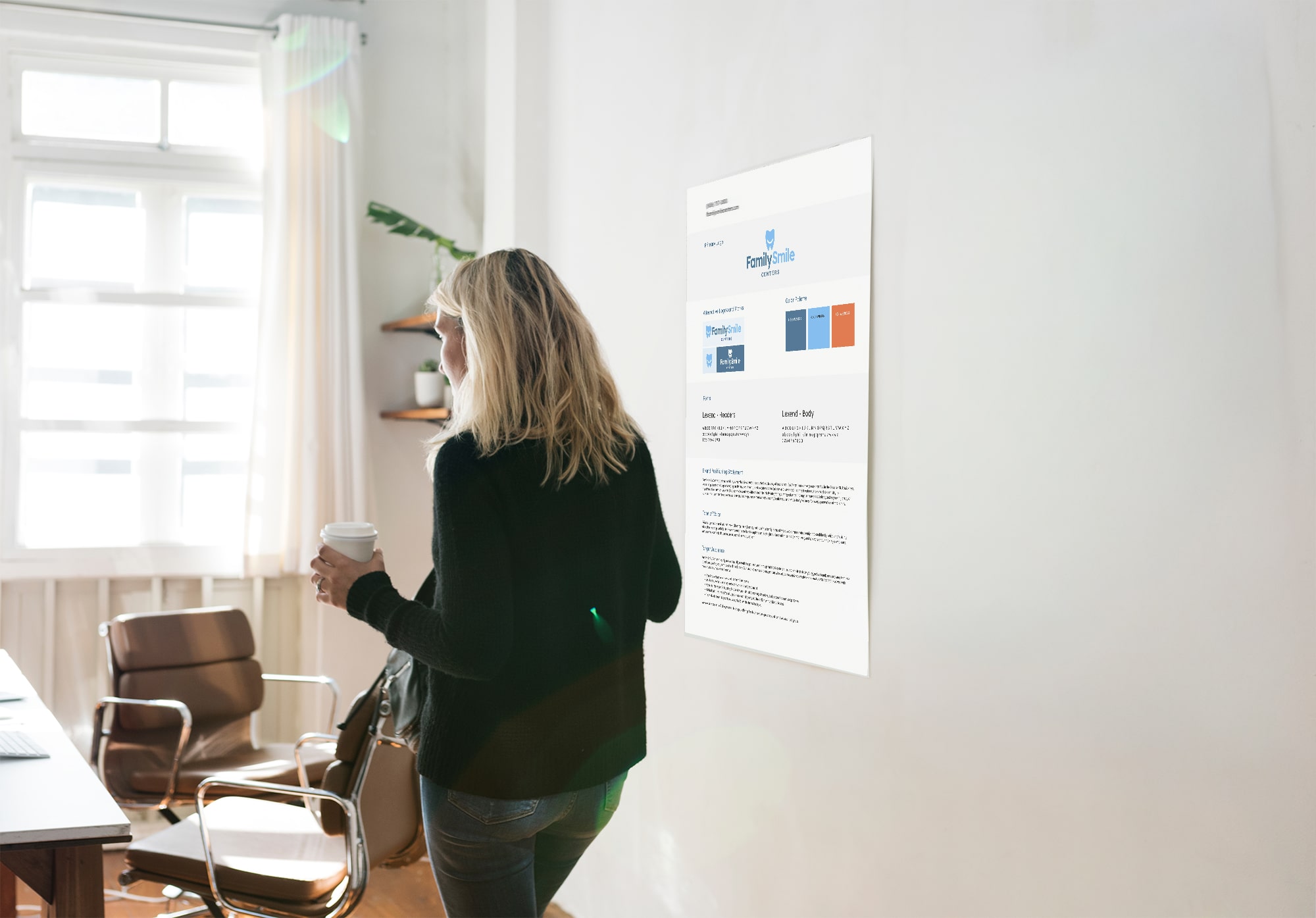 Branding&Strategy-min Woman holding a coffee cup while viewing a branding guidelines poster for Family Smile Centers on the wall.